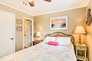 A bedroom with a bed, a nightstand, a lamp, a door, and a framed picture on the wall. - Ocean View, Pools: Hilton Head Resort: STR 072378 (Hilton Head Island)
