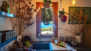 Une cuisine dotée d’une grande fenêtre, d’un évier et de divers ustensiles de cuisine.