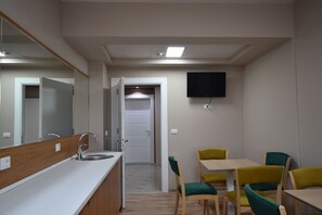 A modern kitchen with a sink, a mirror, and a television mounted on the wall. - Hotel Liss 2 (Lezhe)