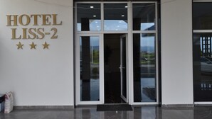 A hotel entrance with a sign reading "HOTEL LISS-2" and three stars.