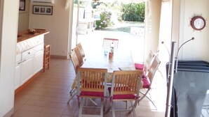 A dining area with a table and chairs, a kitchen area with cabinets and a counter, and a ceiling with nautical decorations.