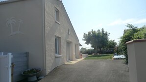 A residential building with a driveway leading to a grassy area.