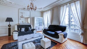 Ein geräumiges Wohnzimmer mit einem modernen Sofa, einem Couchtisch und einer Deckenleuchte.