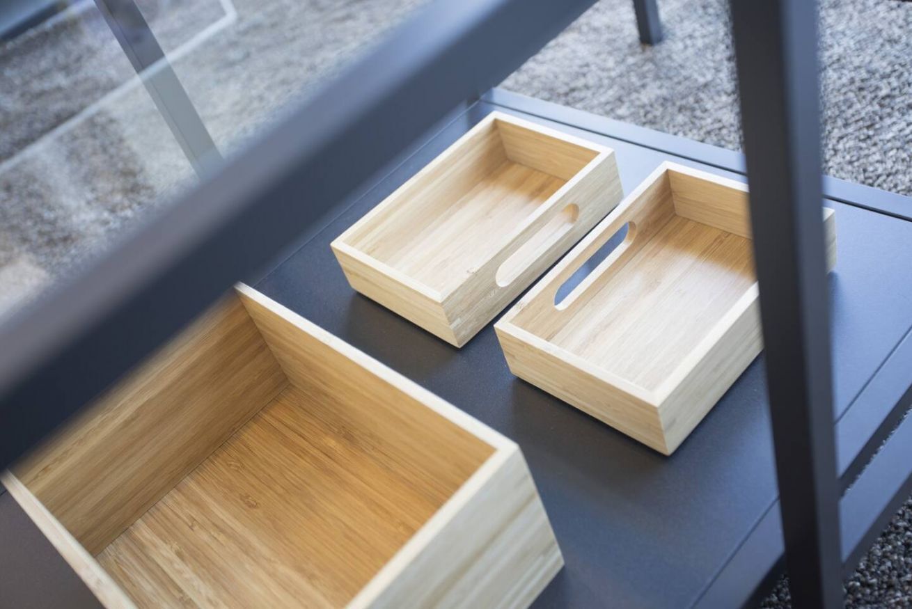 Two wooden storage boxes on a black table.