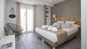 Een moderne slaapkamer met een bed, nachtkastje, stoel en een muur met een motiverende quote.