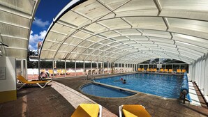 A covered swimming pool with yellow lounge chairs and a clear view of the sky. - Alto Club, Alvor. Quiet, comfortable apartment in this acclaimed holiday resort (Alvor)