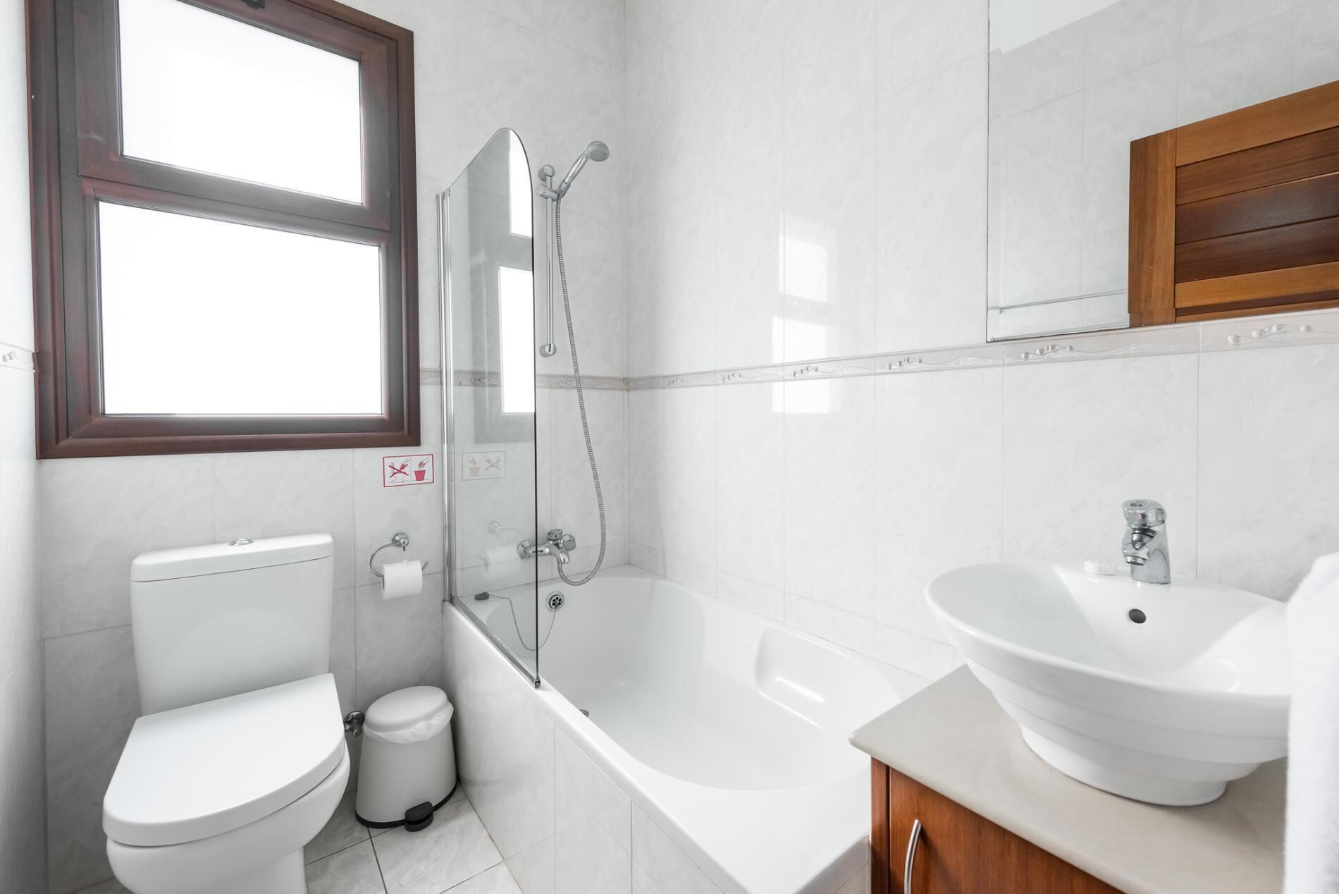 A modern bathroom with a toilet, a shower, and a bathtub.