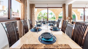 A dining area with a marble table, black and blue tableware, and dark chairs.