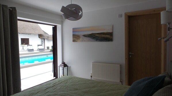 Una camera da letto con vista su una piscina, un termosifone e una porta.
