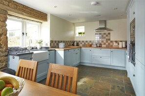 Enjoy cooking in this well-equipped kitchen with a gas stove, oven, and ample natural light.