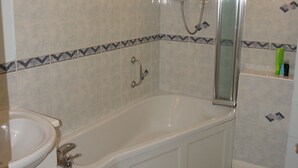 Ein Badezimmer mit Badewanne, Waschbecken und Dusche.