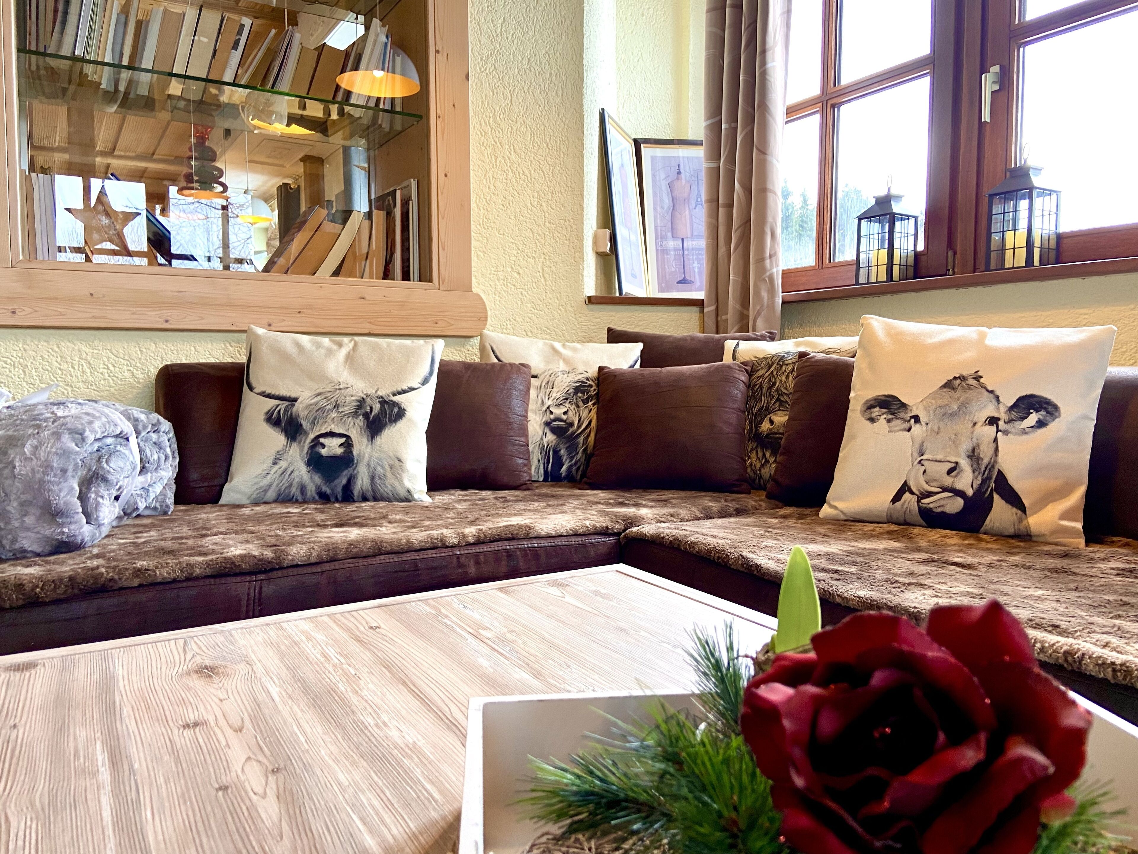 A cozy living room with a wooden sectional sofa, a coffee table, and decorative pillows.