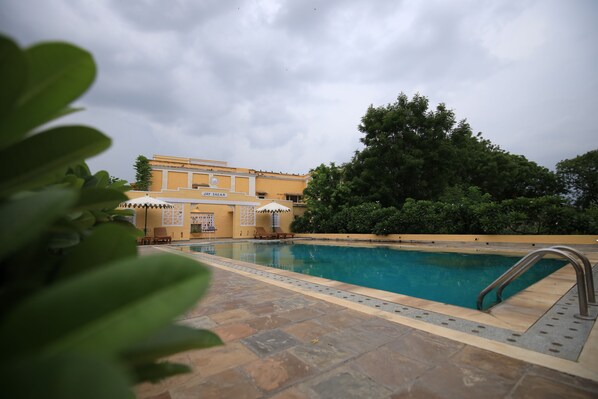 حمّام سباحة خارجي، مظلات على حمّام السباحة، مقاعد للتشمس