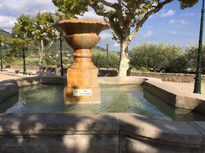 Une fontaine agrémentée d’un panneau indiquant que l’eau n’est pas potable, entourée de structures en pierre et d’arbres.