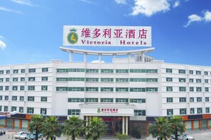 A multi-story hotel building with a prominent sign for Victoria Hotels. - Victoria Hotels (Foshan)