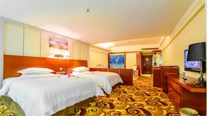 A hotel room with two beds, a television, a desk, and a carpeted floor. - Victoria Hotels (Foshan)
