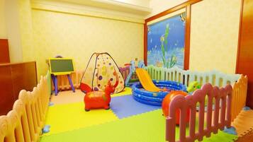 A children's play area with a slide, inflatable pool, and a play tent.