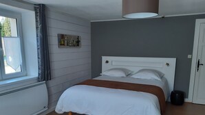 Una camera da letto con un letto, una finestra, un'opera d'arte appesa al muro e una porta.