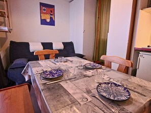 A dining area with a table set for four, featuring patterned tablecloths and blue and white plates.