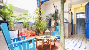 A courtyard with blue furniture, a patterned floor, and potted plants. - Large house, ideal private heated pool for family vacation (Vélez-Málaga)