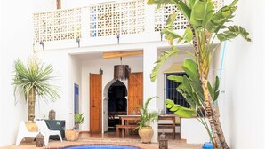 A courtyard with a swimming pool, a wooden door, and potted plants. - Large house, ideal private heated pool for family vacation (Vélez-Málaga)