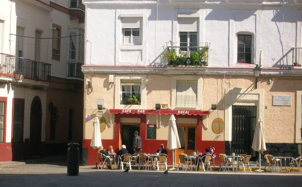 Un café/bar doté d’une terrasse, d’un auvent rouge et d’une enseigne indiquant qu’il s’agit d’un café/bar.