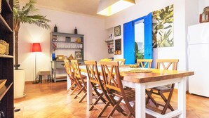 A dining area with a wooden table and chairs, a red lamp, a bookshelf, and a blue door. - Large house, ideal private heated pool for family vacation (Vélez-Málaga)