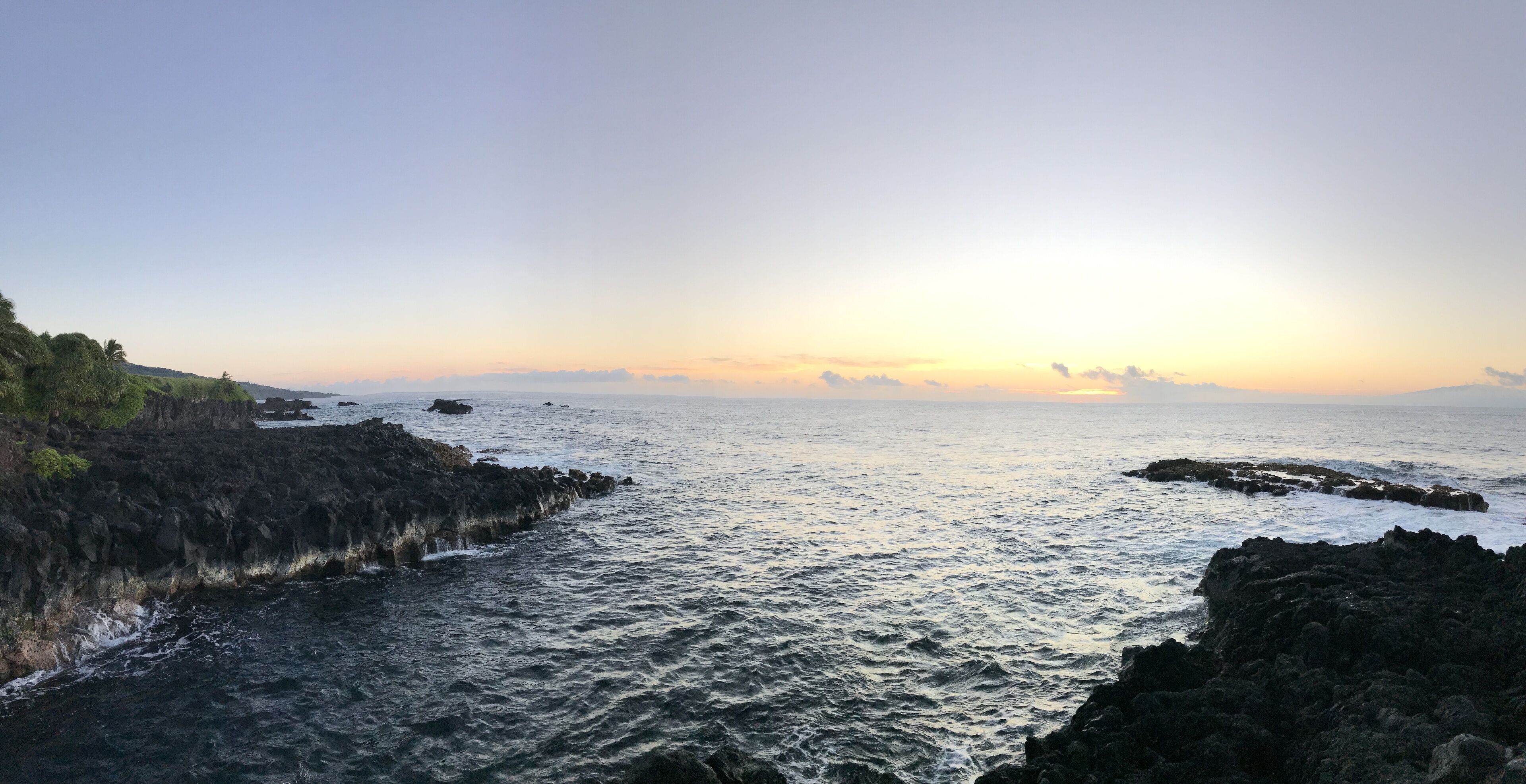 A coastal landscape with rocky terrain and calm sea.