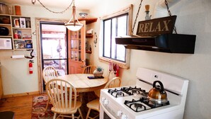 A kitchen with a stove, chairs, a dining table, and a 'RELAX' sign. - Red rock canyon views! Private. Everything you need. Artist touches abound (Sedona)