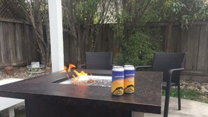A patio with a black grill table, two chairs, and two cans of Santa Cruz beer. - Serenity at Natural Bridges  - 5 min Walk to Beach (Santa Cruz)