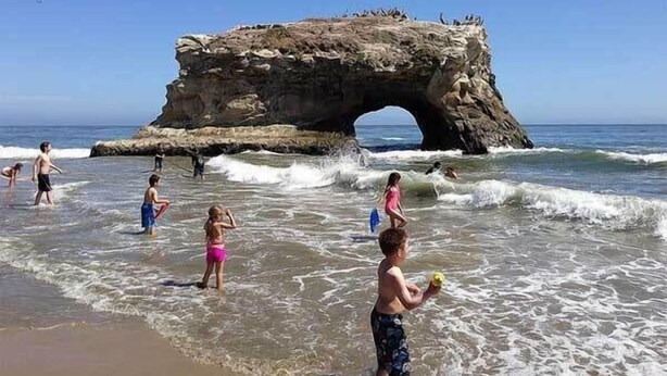 A beach with a large rock formation in the water. - Serenity at Natural Bridges  - 5 min Walk to Beach (Santa Cruz)
