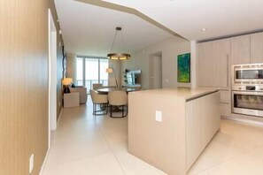 Enjoy meals in the kitchen with an oven and microwave, adjacent to a dining area with a round table and chairs.