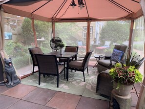 A covered patio area with a table and chairs, a fan, and potted plants. - Bear House 1890, Lilly's Loft, Delightful, Upgraded amenities, Walk to Cafes (Chattanooga)