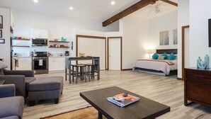 A modern apartment with a kitchen, dining area, and a bedroom.