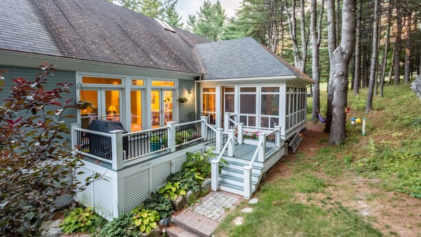 A house with a covered porch, a small deck, and a staircase leading to the entrance.