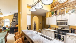 A kitchen with granite countertops, stainless steel appliances, and white cabinetry.