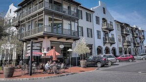 A multi-story building with outdoor seating and a balcony.