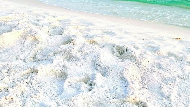 A beach with clear turquoise water and white sand.
