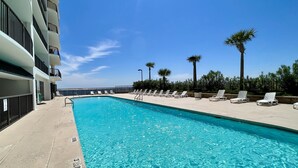 A swimming pool with lounge chairs and palm trees, surrounded by a building with balconies. - Awesome Views!!! Watch the sail boats & seagulls. Two pools. Two hot tubs.
. (Orange Beach)
