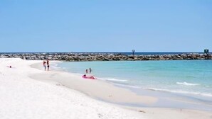 A beach with white sand, a rocky breakwater, and calm blue water. - Awesome Views!!! Watch the sail boats & seagulls. Two pools. Two hot tubs.
. (Orange Beach)