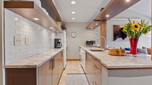 Een moderne keuken met witte metrotegels, houten kastjes en een centraal eiland.