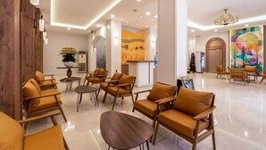 A modern lobby with wooden furniture, a reception desk, and a large mural. - Palago Hotel, Binh Thanh District (Ho Chi Minh City)