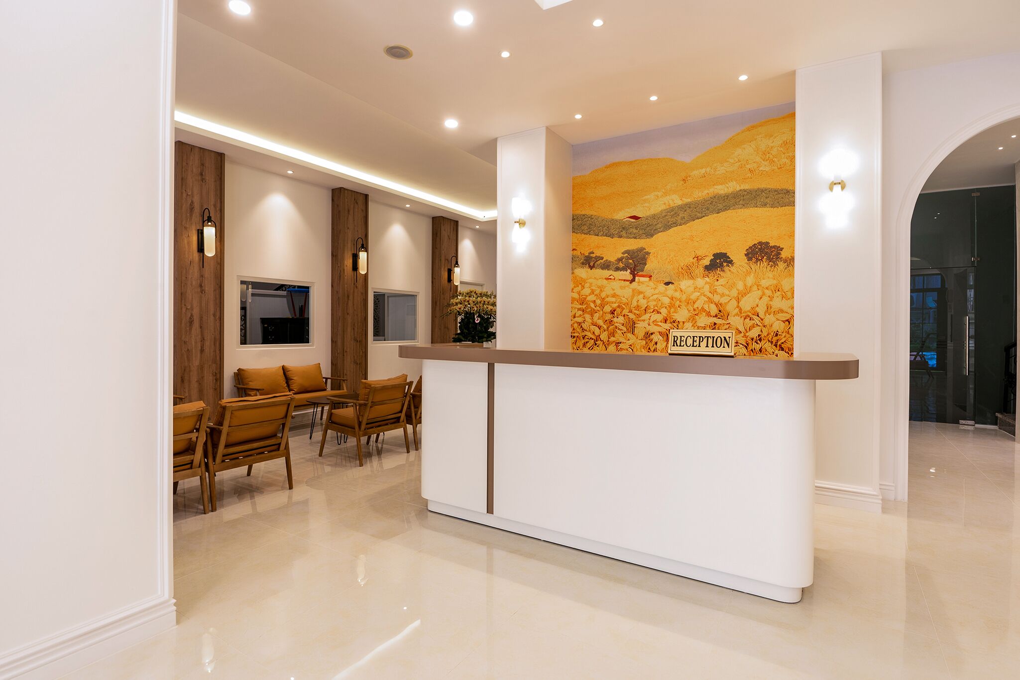 A reception area with a reception desk, wooden chairs, and a mural on the wall.