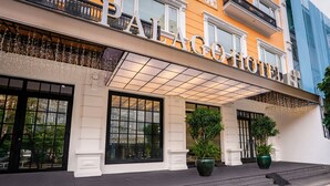 A hotel entrance with large windows, a covered entrance area, and potted plants. - Palago Hotel, Binh Thanh District (Ho Chi Minh City)