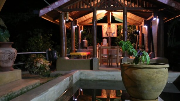 A gazebo with a table and chairs, surrounded by potted plants and a small water feature. - Plantation Retreat (Pathadumbara)