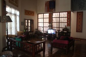 A traditional living room with a television, wooden furniture, and decorative items. - Plantation Retreat (Pathadumbara)