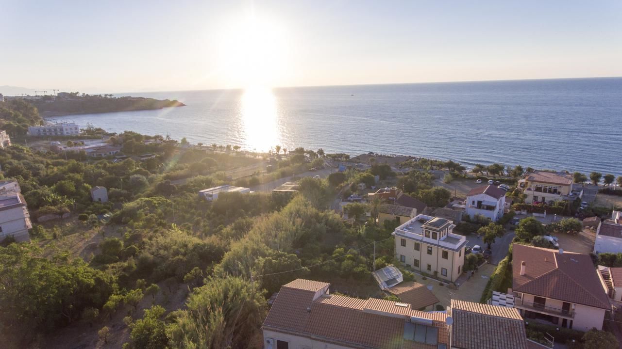 A coastal residential area with houses and a view of the sea.