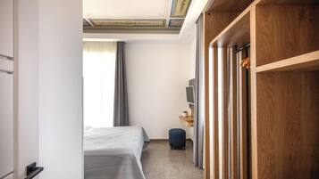 A hotel room with a bed, a desk, a television, and a wardrobe.