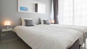 A hotel room with a large bed, two bedside tables with lamps, a mirror above the bed, and a window with curtains. - Sweethome26 Luxury Apt With Parking (Tel Aviv)