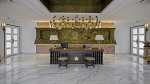 Um hall com piso de mármore, lareira de tijolos e um candelabro.